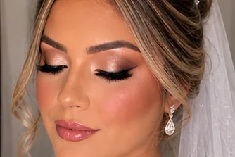 Noiva de olhos fechados com maquiagem iluminada nos olhos, véu e tiara